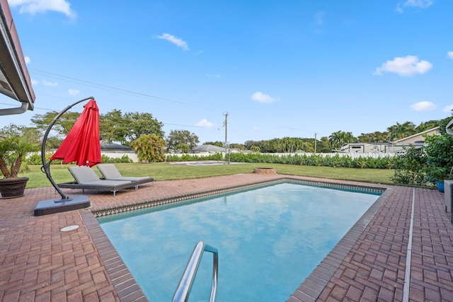 view of pool featuring a lawn and a patio