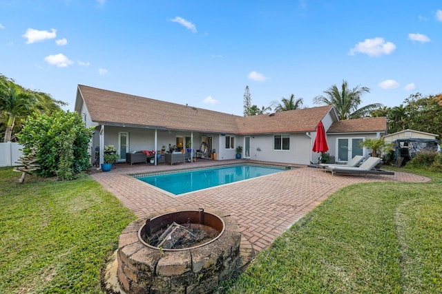 view of pool with a patio area, an outdoor living space with a fire pit, and a yard