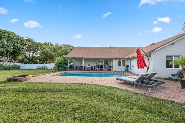 view of swimming pool featuring an outdoor living space with a fire pit, a lawn, and a patio