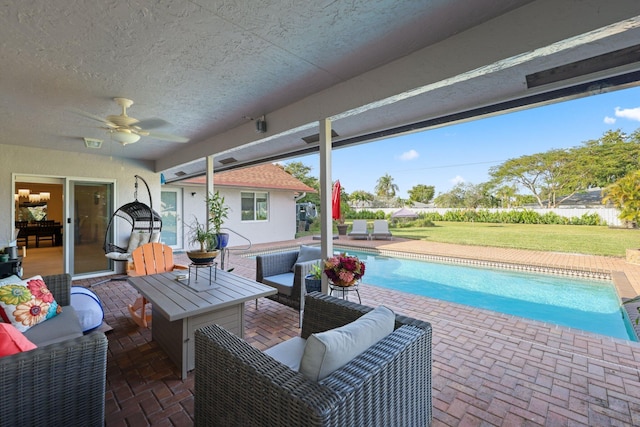 view of swimming pool featuring an outdoor living space, a patio, a yard, and ceiling fan