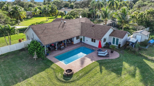 view of swimming pool with a yard, a patio area, an outdoor fire pit, and a storage shed