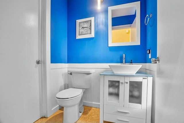 bathroom with toilet, vanity, and tile patterned floors