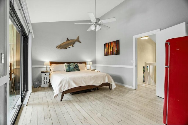 bedroom featuring ceiling fan, light wood-type flooring, fridge, and high vaulted ceiling