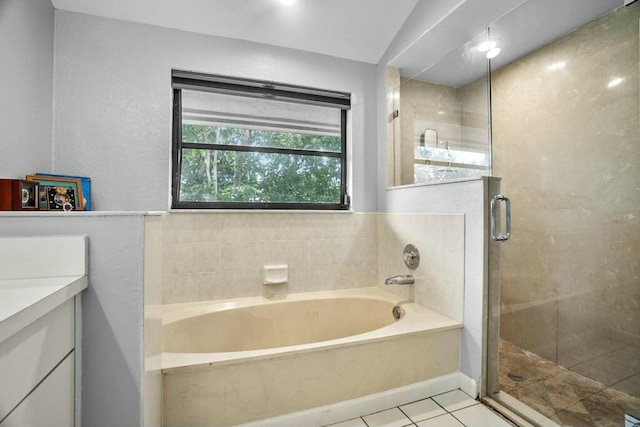 bathroom featuring lofted ceiling, vanity, tile patterned flooring, and shower with separate bathtub