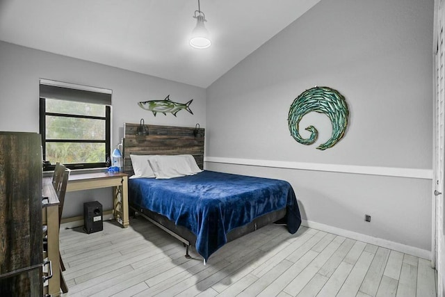 bedroom with lofted ceiling and light hardwood / wood-style floors