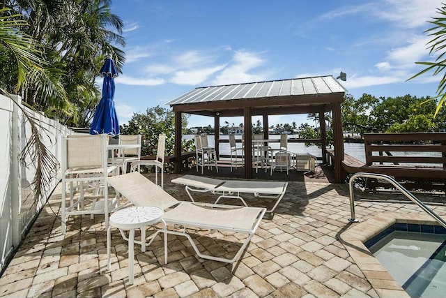 view of patio / terrace with a water view, a gazebo, and a pool