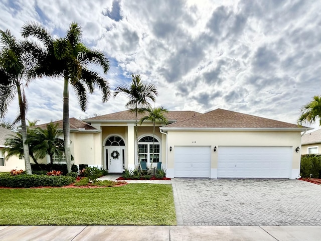 view of front of property with a front lawn and a garage