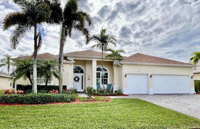 view of front of property featuring a front lawn and a garage