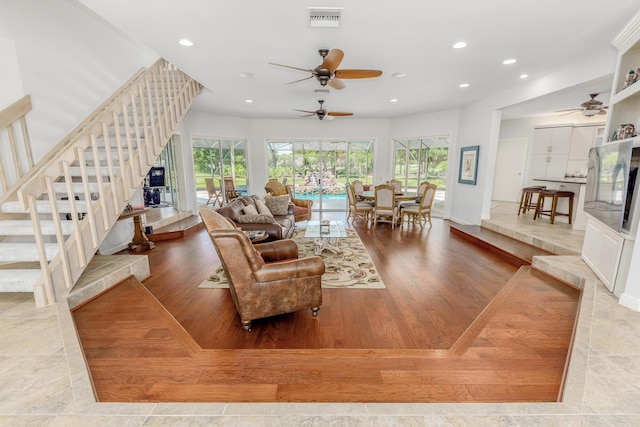 living room featuring plenty of natural light, ceiling fan, and light wood-type flooring