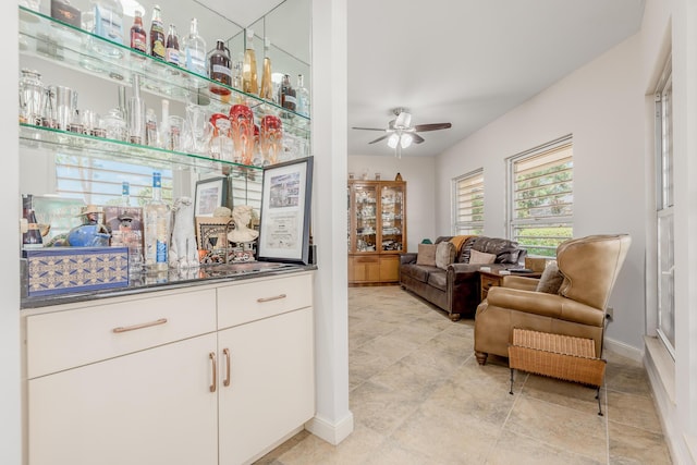 bar featuring white cabinetry and ceiling fan