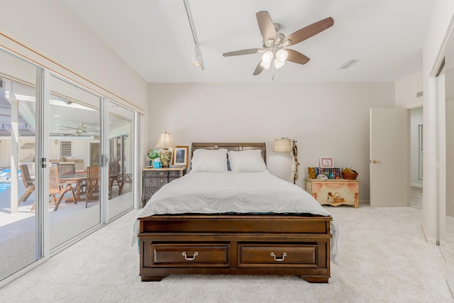 carpeted bedroom with ceiling fan, access to outside, and track lighting