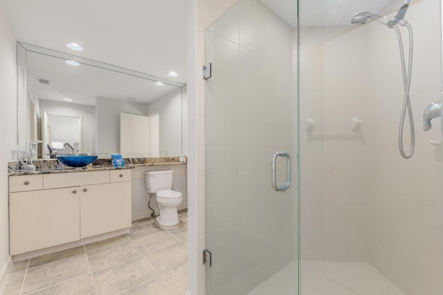 bathroom featuring a shower with door, vanity, and toilet