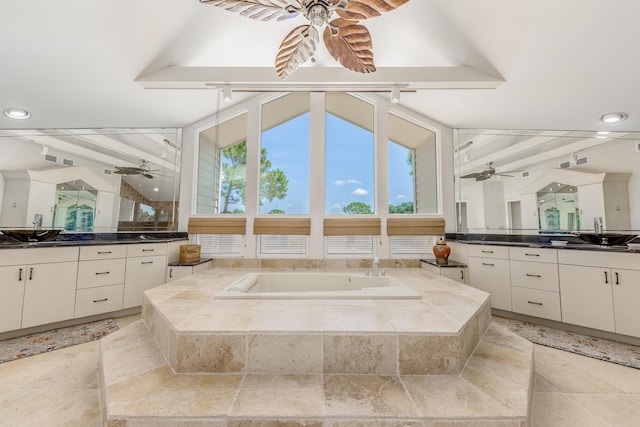 bathroom with vanity, vaulted ceiling with beams, and a relaxing tiled tub