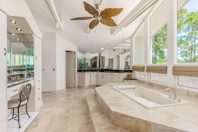 bathroom featuring tiled bath, ceiling fan, and vanity