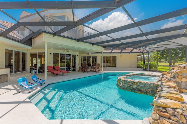 view of pool featuring a lanai, a patio area, an in ground hot tub, and ceiling fan