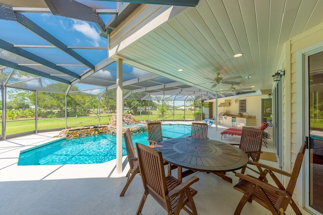 view of swimming pool with glass enclosure, ceiling fan, pool water feature, and a patio