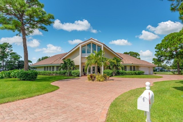 view of front of home with a garage and a front lawn