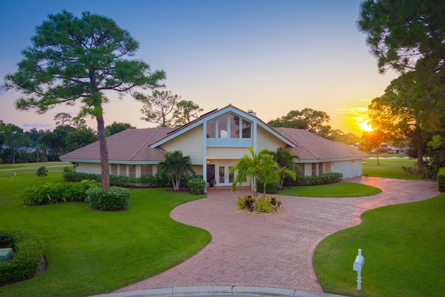 view of front of home with french doors and a lawn