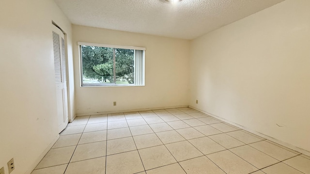 tiled spare room with a textured ceiling