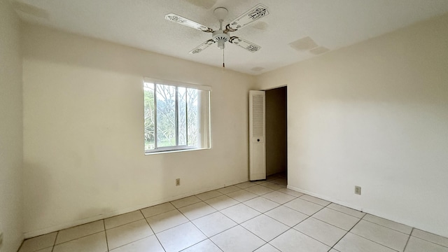 unfurnished room with light tile patterned floors and ceiling fan