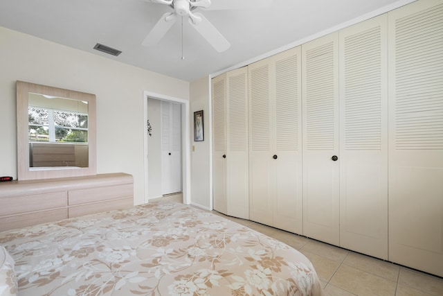 unfurnished bedroom with ceiling fan, two closets, and light tile patterned flooring