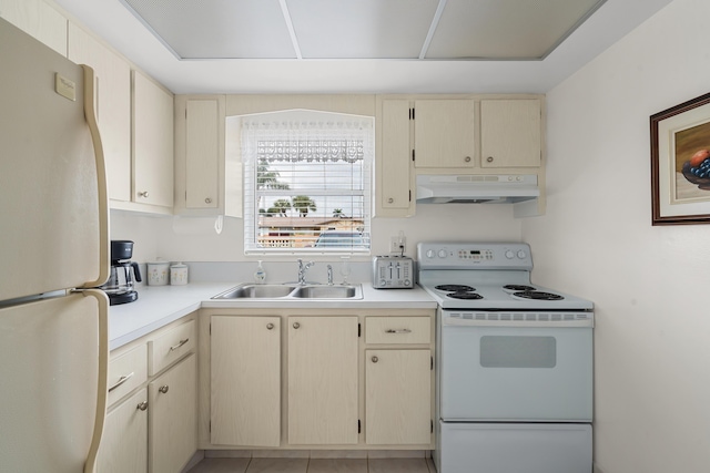 kitchen with white appliances, cream cabinets, and sink