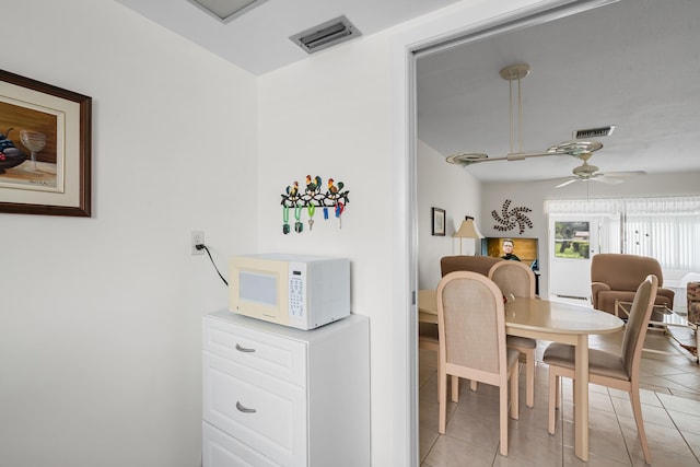 tiled dining space with ceiling fan