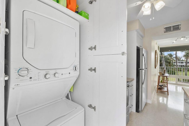 clothes washing area with stacked washer / dryer