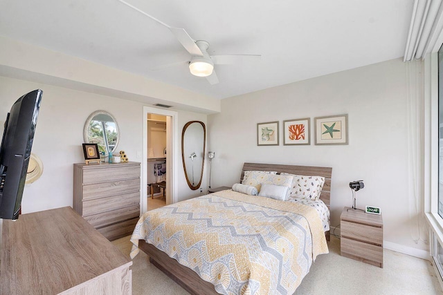 bedroom featuring light carpet, a spacious closet, a closet, and ceiling fan