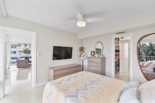 bedroom with a walk in closet, a closet, and ceiling fan