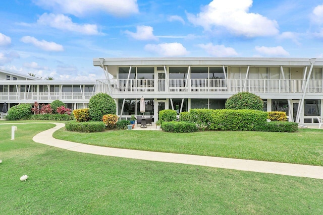 rear view of house featuring a patio and a yard