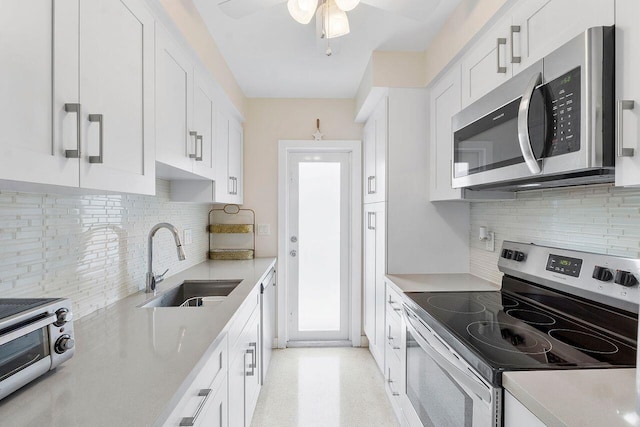 kitchen with stainless steel appliances, white cabinetry, and sink