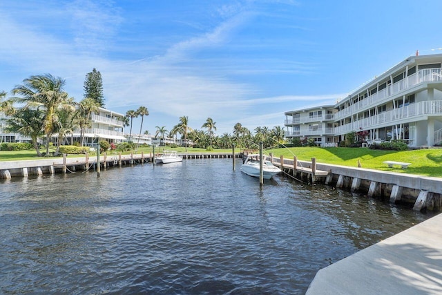 view of dock featuring a water view and a yard