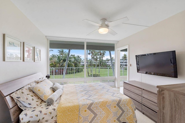 bedroom featuring access to outside, ceiling fan, and a wall of windows