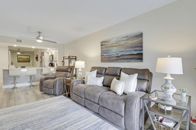 living room featuring ceiling fan and light wood-type flooring