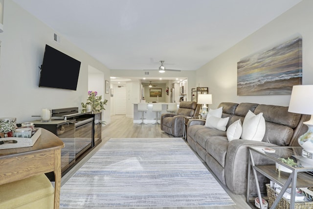 living room with ceiling fan and light hardwood / wood-style floors