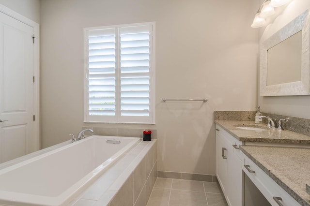 bathroom featuring tiled bath, a wealth of natural light, tile patterned floors, and vanity