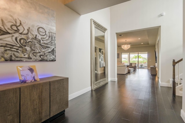 hall featuring dark hardwood / wood-style floors and a notable chandelier