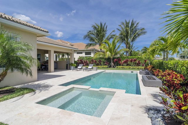 view of pool featuring an outdoor fire pit, an in ground hot tub, and a patio