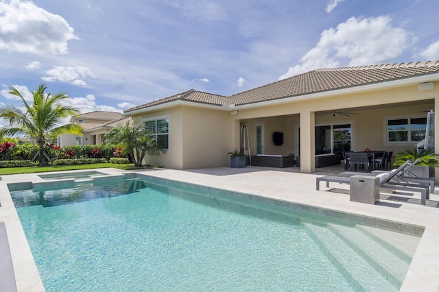 view of swimming pool with ceiling fan, a patio area, and an in ground hot tub