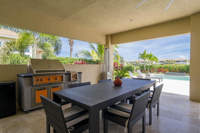 view of patio / terrace featuring a fenced in pool, an outdoor kitchen, and grilling area