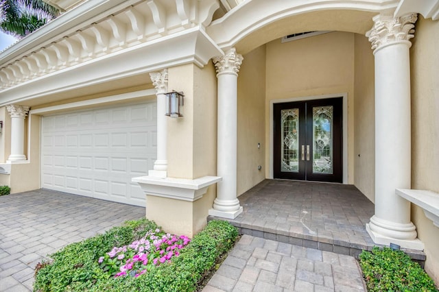 property entrance featuring a garage and french doors