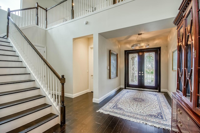 foyer entrance featuring french doors, dark wood-type flooring, and a high ceiling