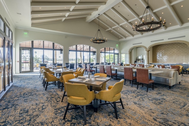 dining area with carpet floors, a high ceiling, french doors, and an inviting chandelier