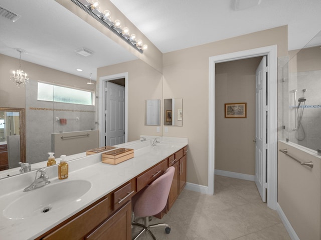 bathroom featuring a tile shower, tile patterned flooring, vanity, and an inviting chandelier