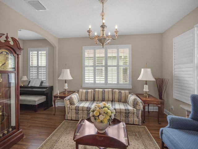 living room featuring dark wood-type flooring and an inviting chandelier