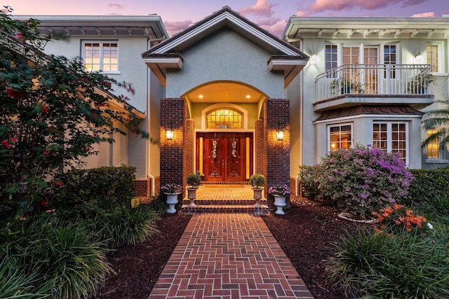 exterior entry at dusk with a balcony