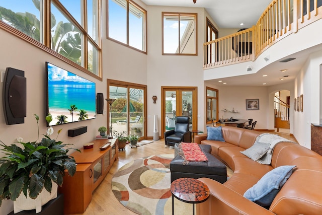 living room with a high ceiling and light hardwood / wood-style flooring