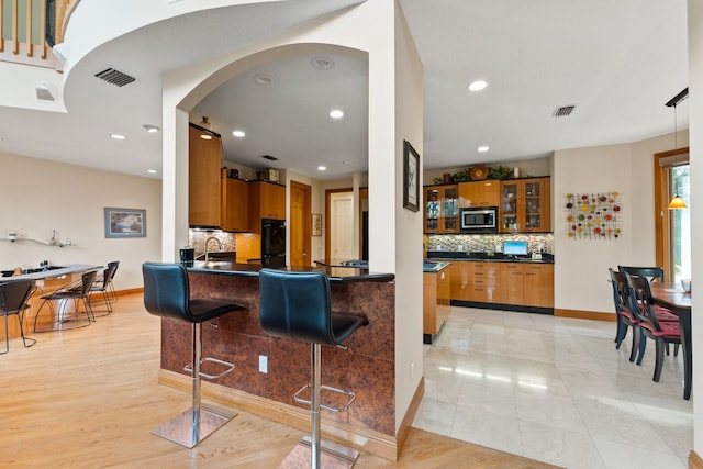 kitchen featuring backsplash, sink, pendant lighting, and a kitchen breakfast bar