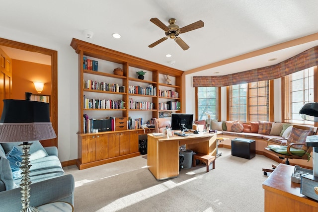 home office with light carpet and ceiling fan